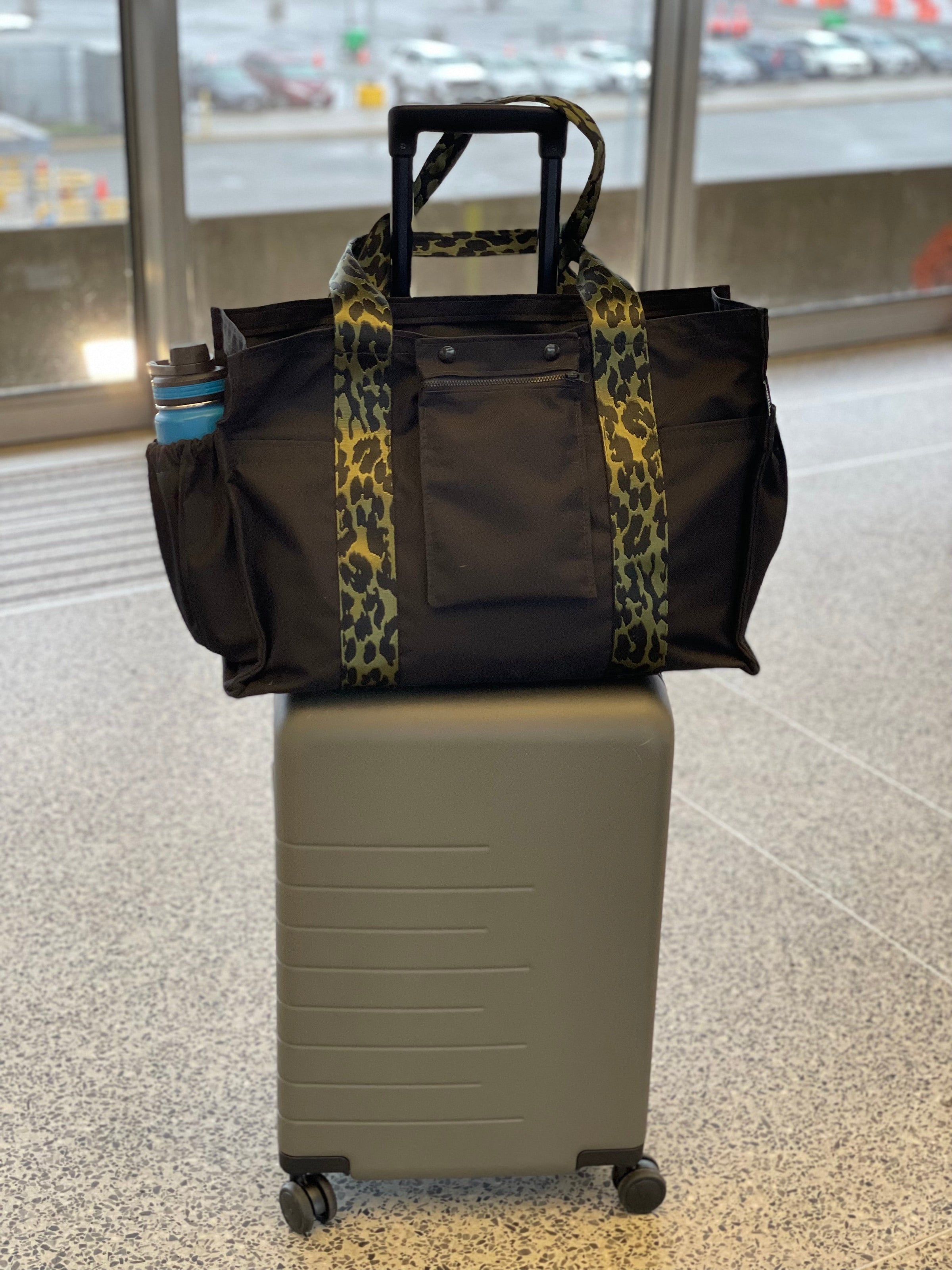 Mustkies Sydney Tote on a suitcase at the airport terminal