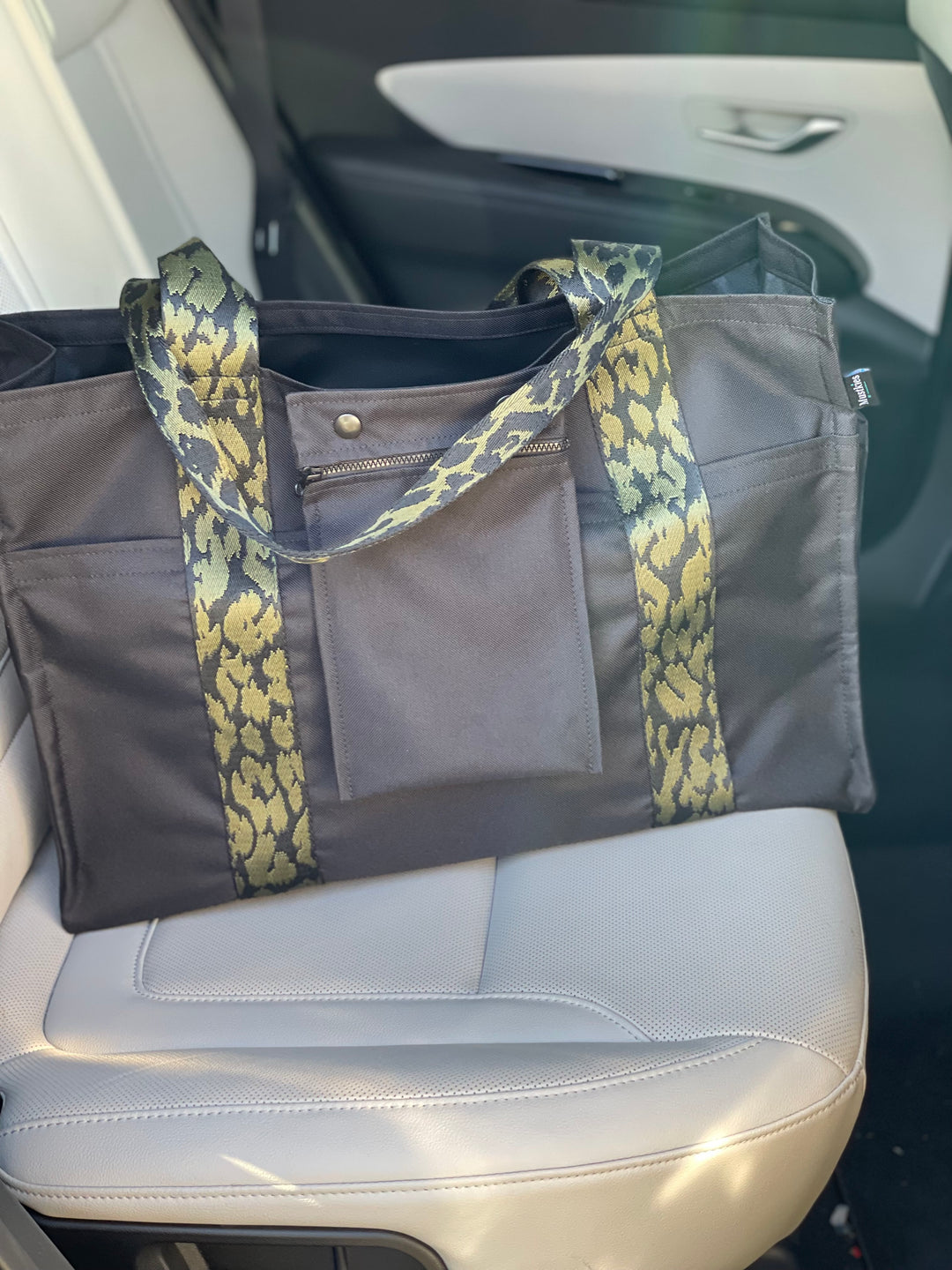 Mustkies Travel Tote in a black waterproof canvas and finished with a green camouflage strap.