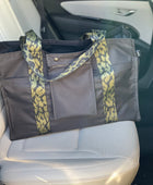 Mustkies Travel Tote in a black waterproof canvas and finished with a green camouflage strap.