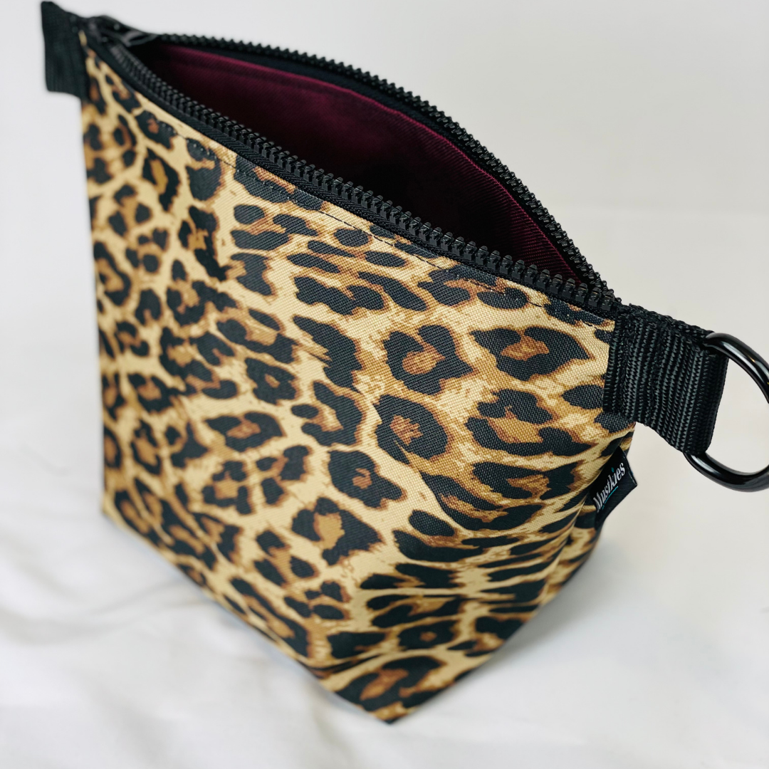 Mustkies VOYAGE Travel Toiletry Make-Up Kit. Crafted in waterproof canvas in Cheeta print and wine linning.