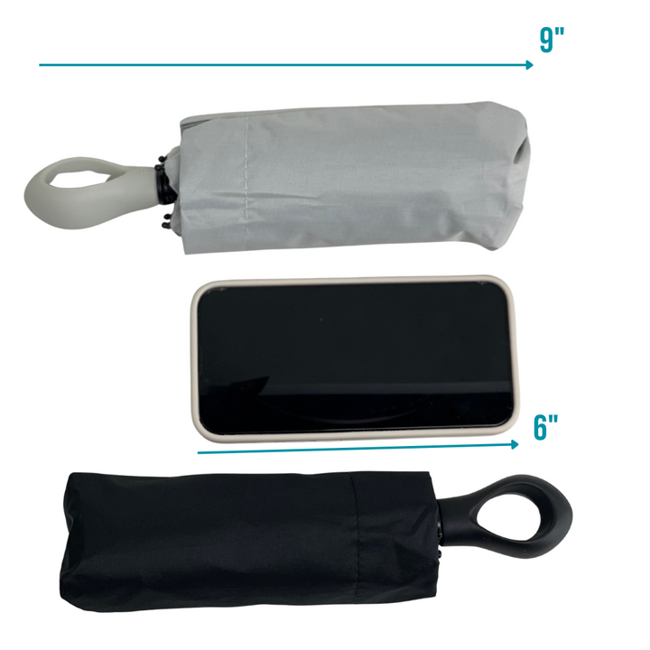 Comparison of a compact gray umbrella, a smartphone, and a compact black umbrella with measurements indicated.