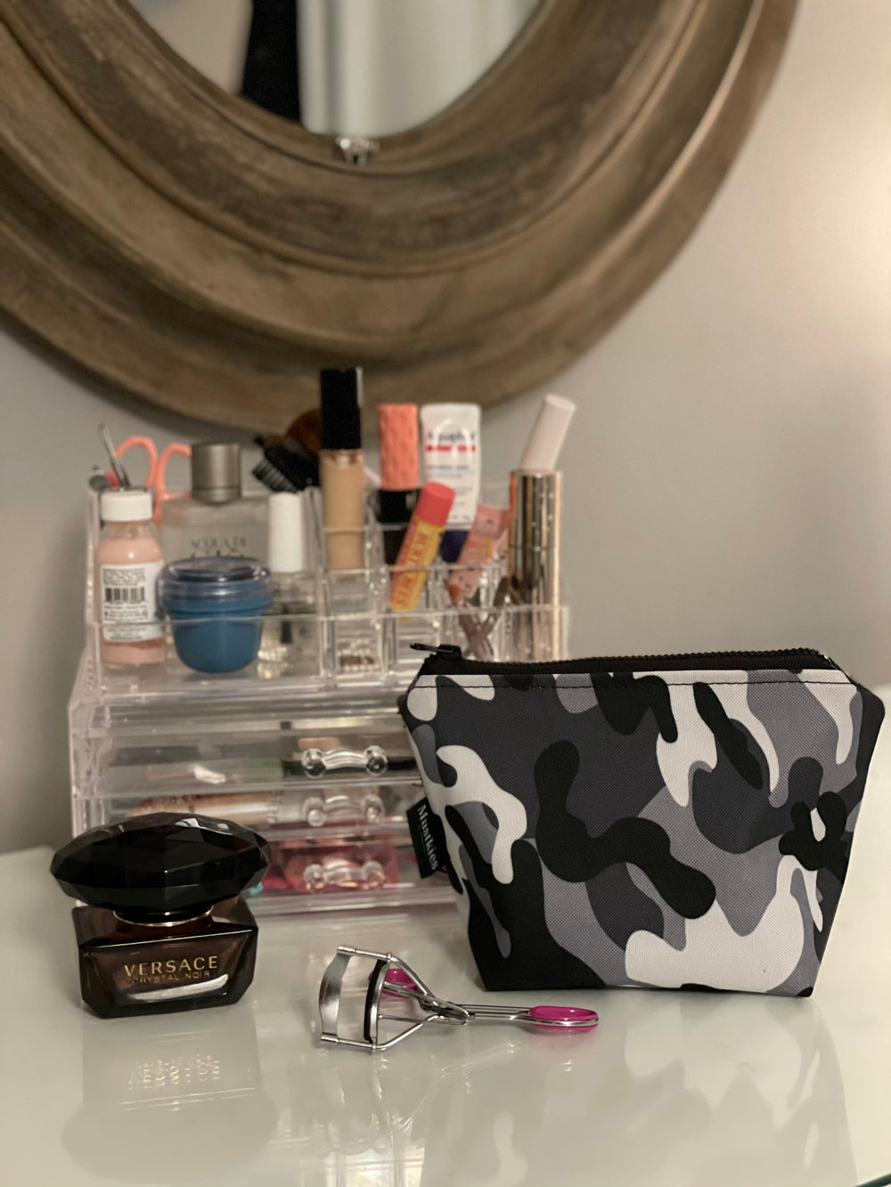 Muskties AMI Make-up bag. Handcrafted in waterproof canvas and finished with a black zipper to secure your make-up/cosmetics. Available in 6 color options and two sizes. Image of the cosmetic bag on a counter 