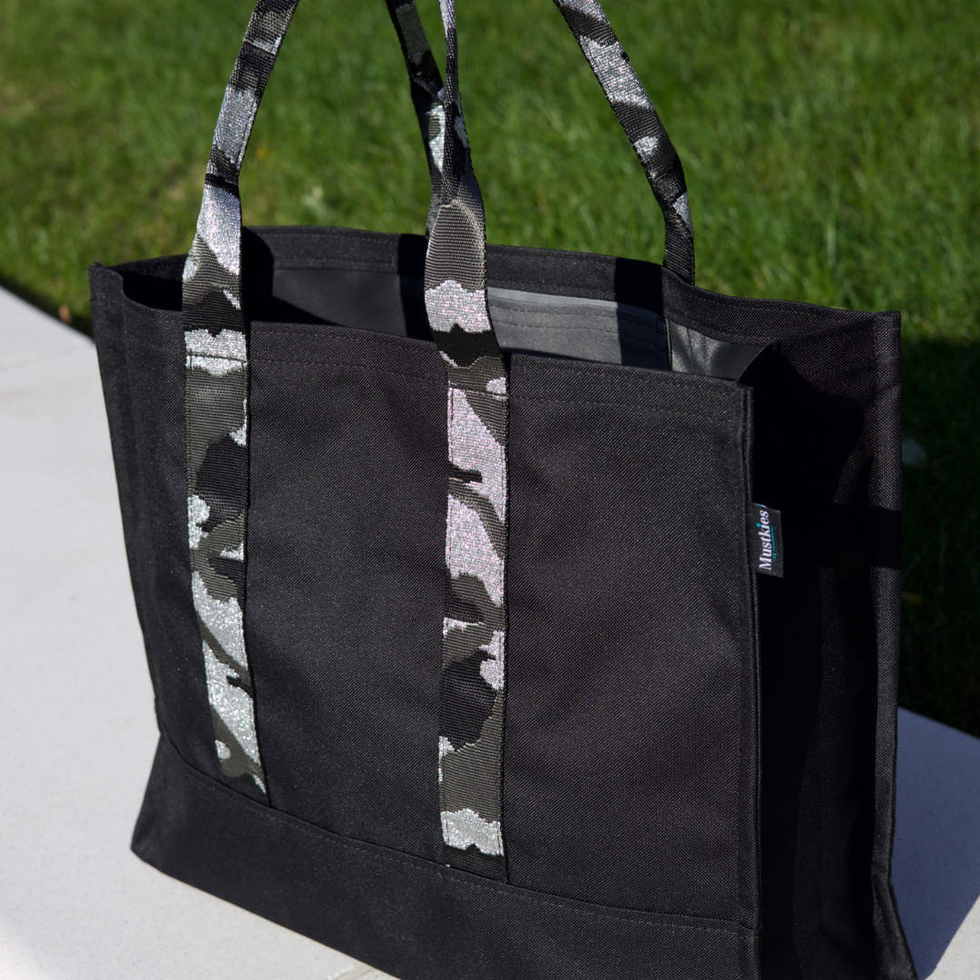 Mustkies CARRIE Tote is your go-to tote. Crafted in a black waterproof canvas with gray lining and camouflage straps. It is a versatile, lightweight everyday bag. Another must-have for running errands, schlepping gear to the kids games, for the beach or even carrying groceries home from the market. White Plains, NY. Westchester County