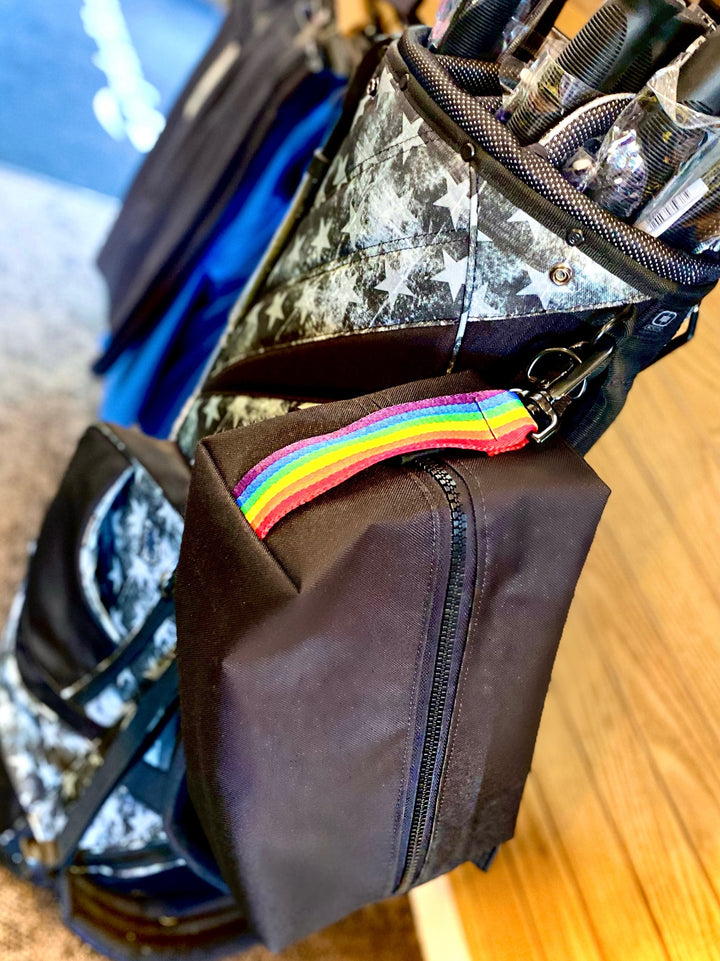 Mustkies LIZZIE Black Golf Shoe Bag with Rainbow Strap. Handmade in White Plains NY. Westchester County. Image taken on a golf bag at Saxon Woods Golf Pro Shop in Scarsdale NY.