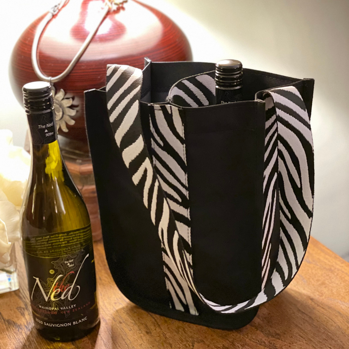 CHEERS! Mustkies Black must have on-the-go wine & beverage bag trimmed in a zebra Strap. Extremely stylish and perfect to help you look your best while transporting your beverages to different events. Handmade in White Plains NY. Available in 4 colorways & Customizable. Size: 11T x 4.5W x 8L Perfect GIFT for wine lovers! Celebrate the holiday season with a stylish, unique design sprits bag!!!