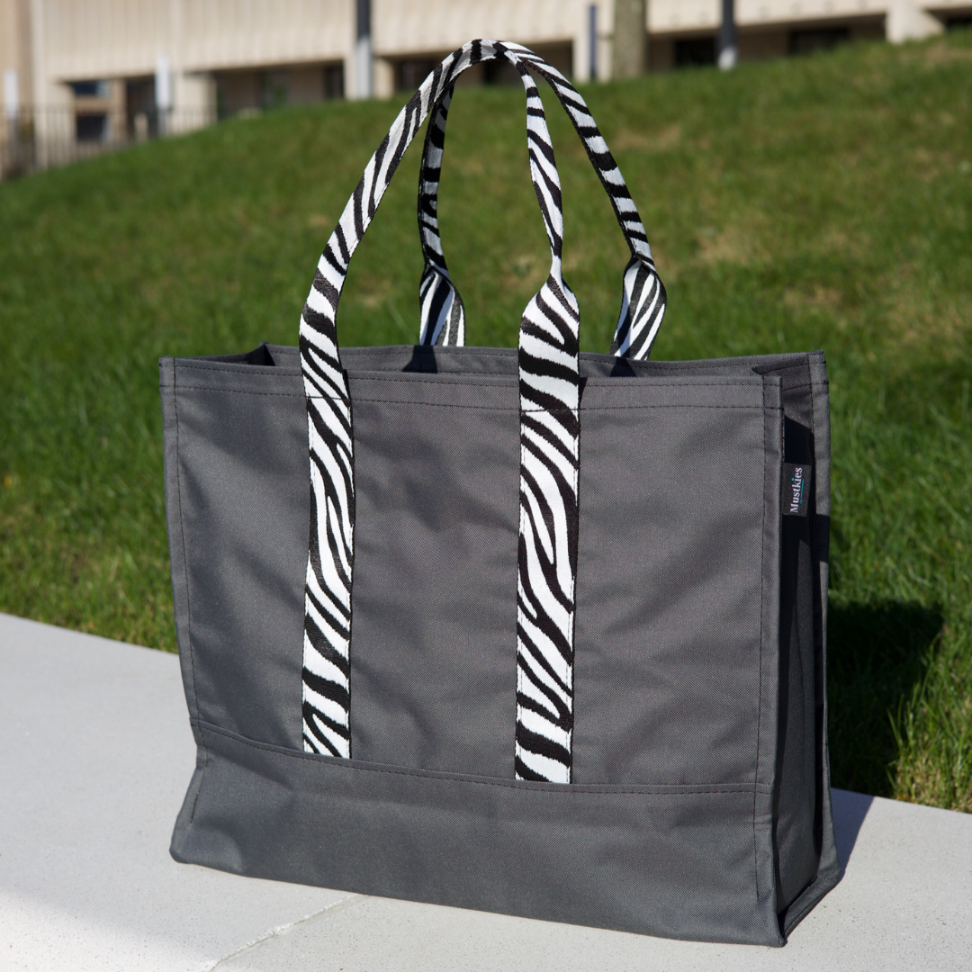 Mustkies CARRIE Tote is your go-to tote. Crafted in a gray waterproof canvas with black lining and zebra straps. It is a versatile, lightweight everyday bag. Another must-have for running errands, schlepping gear to the kids games, for the beach or even carrying groceries home from the market. White Plains, NY. Westchester County