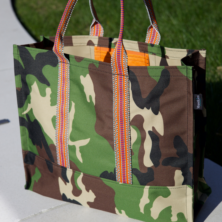 Mustkies CARRIE Tote is your go-to tote. Crafted in a Camouflage waterproof canvas with orange lining and straps. It is a versatile, lightweight everyday bag. Another must-have for running errands, schlepping gear to the kids games, for the beach or even carrying groceries home from the market. White Plains, NY. Westchester County