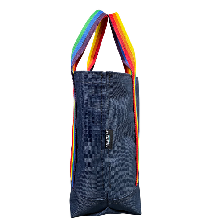 Mustkies LENA Navy Small tote th water bottle sleeve inside to secure your water. Finished in wia rainbow strap.Avaliable in 5 colors. Side view. Handmade by Geraldine Signer in White Plains NY 10605