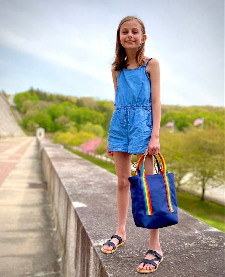 Mustkies LENA in Navy Canvas tote finished with Rainbow Strap. Modeled by child. Photo taken at The Kensico Reservoir located in the towns of Armonk and Valhalla, New York. Handbag handmade by Geraldine SIgner, Founder and Designer of Mustkies GS Creative Designs.  Small business located In White Plains, NY 10605.  Westchseter County
