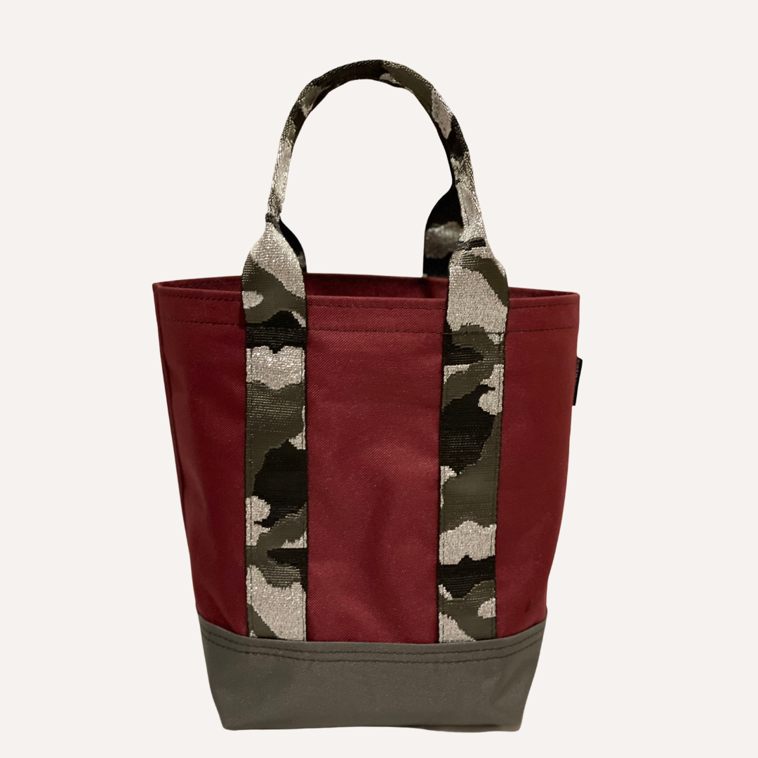 Mustkies LENA Handmade shopper tote for both adults and kids. Crafted in a wine waterproof canvas finished in a camouflage strap. Great for looking stylish and going shopping with mommy/daddy and friends! Lots of room for your accessories and more. Three inside pockets and 1 mask/key holder. Holds against all types of wear and tear and perfect for all types of indoor and outdoor use. The Tote bag is 7.5"L x 5.5 W x 10" Tall. 5" drop. White Plains NY Small Women Owned Business. Westchester County