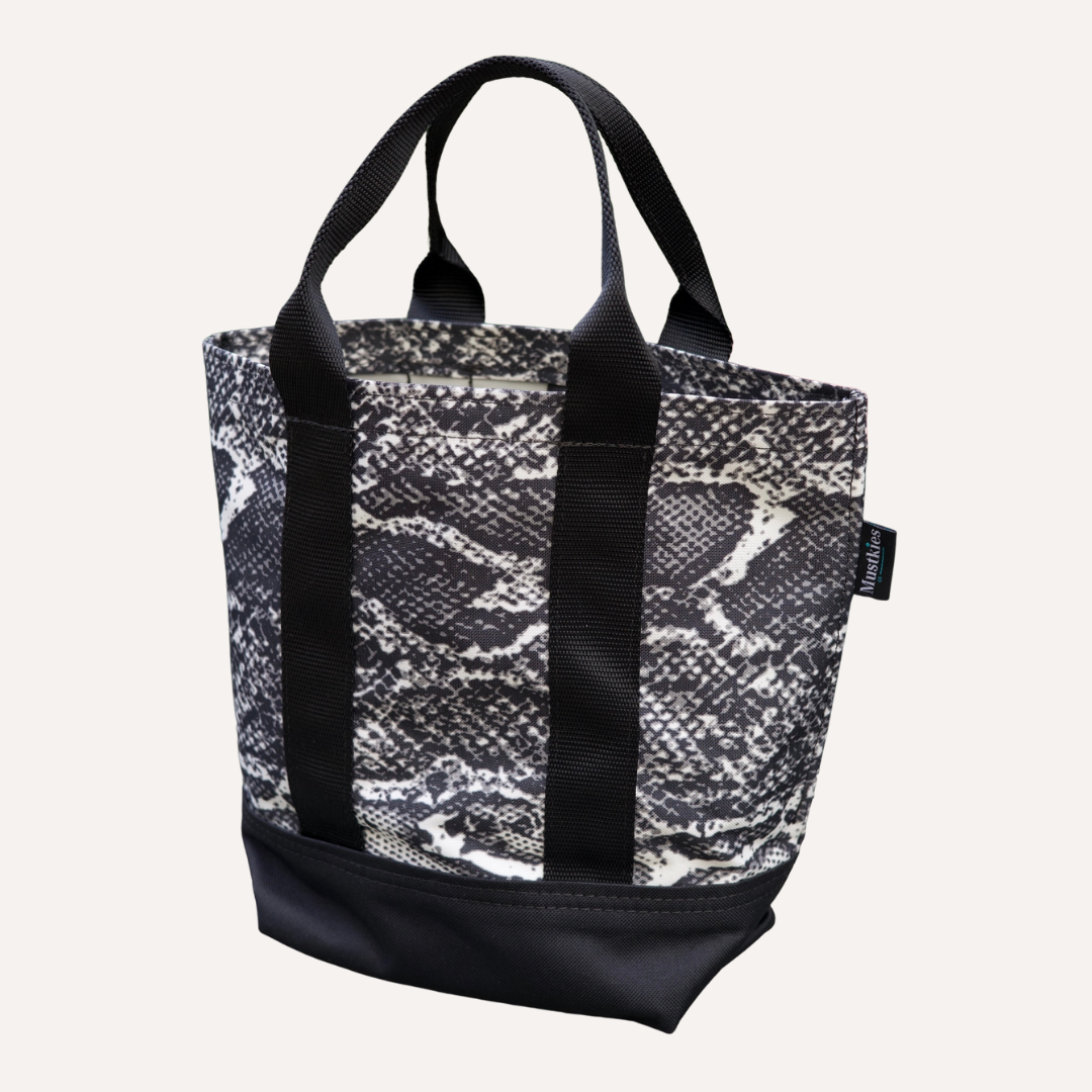 Mustkies LENA Handmade shopper tote for both adults and kids. Crafted in a black and white snake skin waterproof canvas. Great for looking stylish and going shopping with mommy/daddy and friends! Lots of room for your accessories and more. Three inside pockets and 1 mask/key holder. Holds against all types of wear and tear and perfect for all types of indoor and outdoor use. The Tote bag is 7.5"L x 5.5 W x 10" Tall. 5" drop. White Plains NY Small Women Owned Business. Westchester County