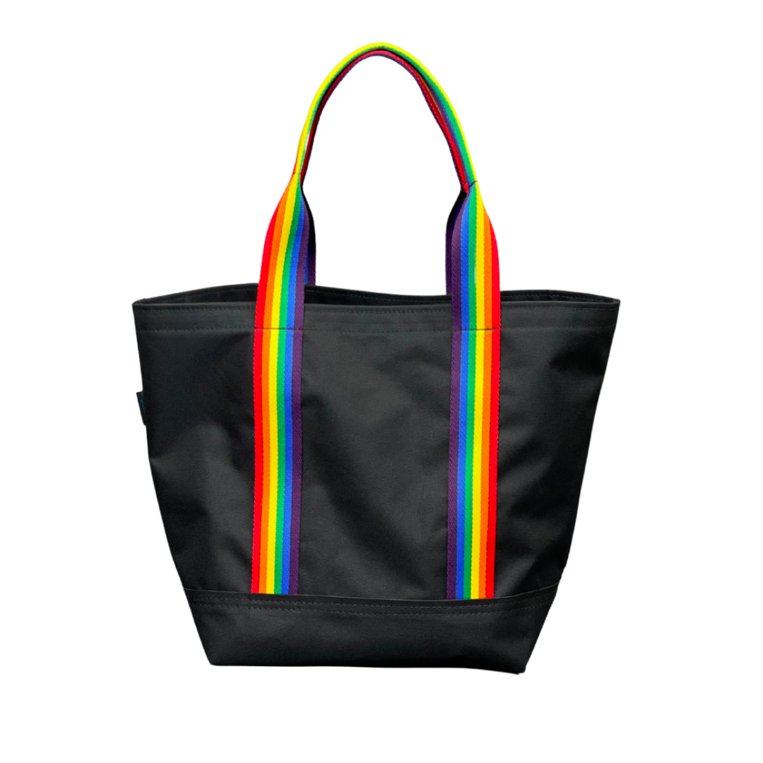 Mustkies Black Waterproof Canvas Milou Shopper Tote with Rainbow Webbing. Ultimate Everyday Shopping Tote Bag. Perfect for running errands. Handcrafted with Waterproof Oxford Canvas, which makes it very easy to clean and finished with a Nylon Rainbow Strap. Available in 6 color options. Finished size 10"L x 8"W x 12"T