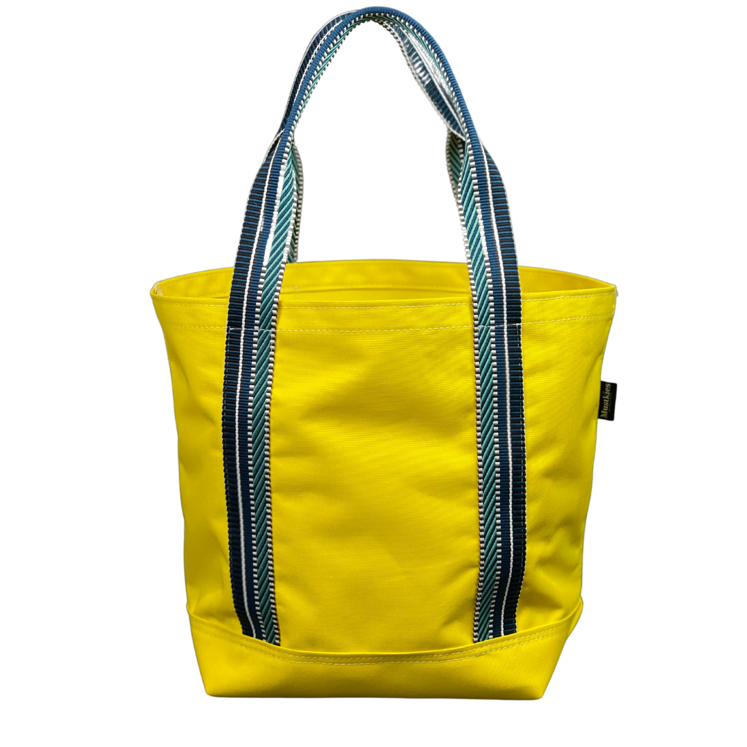 Mustkies Yellow Waterproof Canvas Milou Shopper Tote with Navy/Teal Webbing. Ultimate Everyday Shopping Tote Bag. Perfect for running errands. Handcrafted with Waterproof Oxford Canvas, which makes it very easy to clean and finished with a Nylon Rainbow Strap. Available in 6 color options. Finished size 10"L x 8"W x 12"T